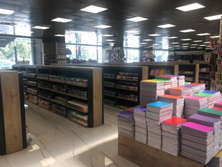 BKM Kitap Bursa Kitap rafları ve üst üste dizilmiş defterlerle koridor görünümü